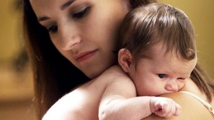 cara de una mujer abrazando a su bebé