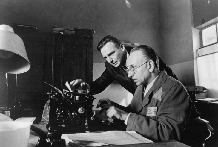 Datos sobre películas; La lista de Schindler con Liam Neeson; dos hombres con traje escribiendo en una máquina de escribir