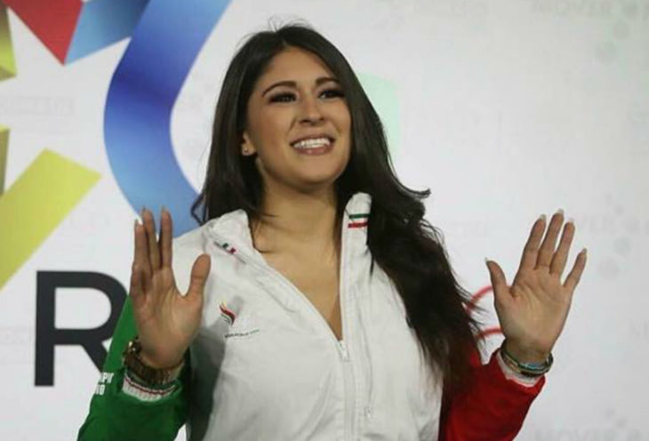 Paola Pliego Lara en un podium levantando los brazos