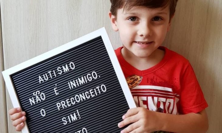 Rafael Mayer el niño autista sosteniendo un letrero