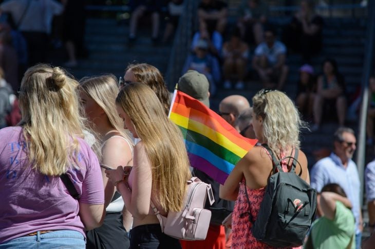varias mujeres durante una marcha llevan la bandera del orgullo gay