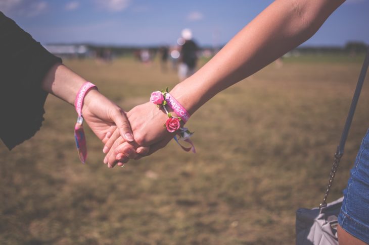 las manos de dos mujeres unidas y un campo de fondo