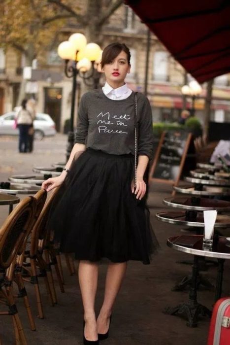 Chica dentro de un café modelando una falsa de tul en negro con sudadera gris claro