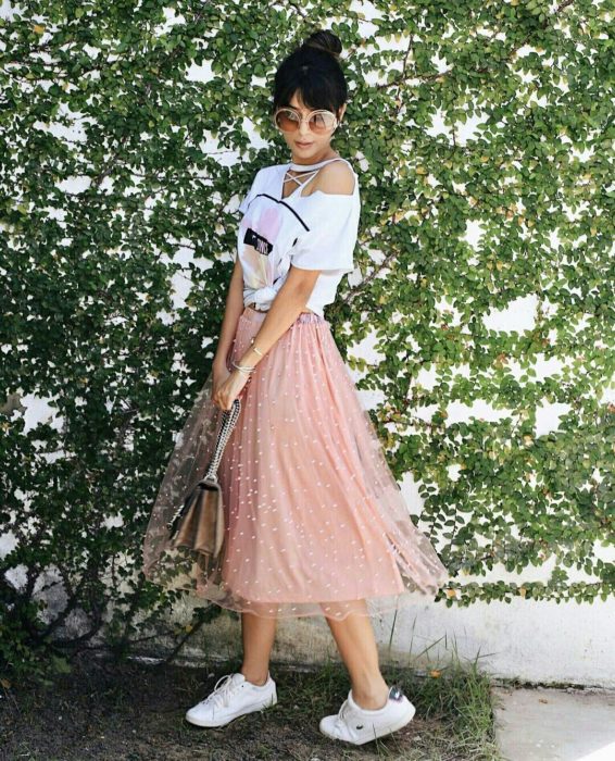 Chica modelando una falda rosa de tul con puntos blancos y bolso en plata