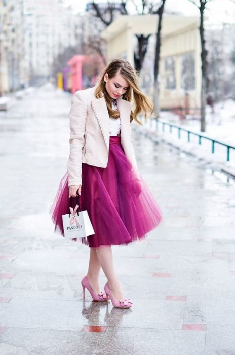 Chica con falda de tul en tono rosa fuscia, modelando su ropa y zapatos del mismo color