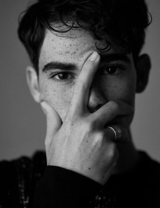 Cameron Boyce cubriendo su rostro con una mano