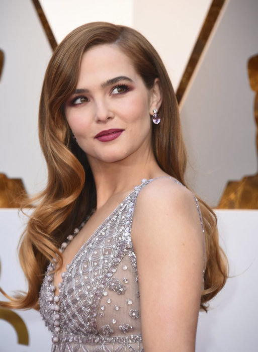 Zoey Deutch usando un vestido gris durante la alfombra roja de los premios Oscar 