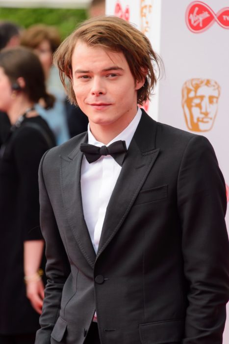 Charlie Heaton usando un traje mientras desfila por la alfombra roja de los premios BAFTA