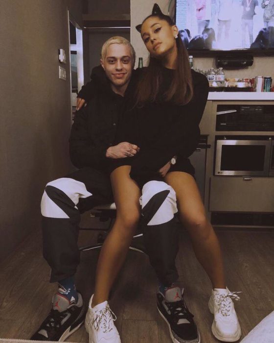 Ariana Grande sentada en las piernas de Pete Davidson, comediante de SLN