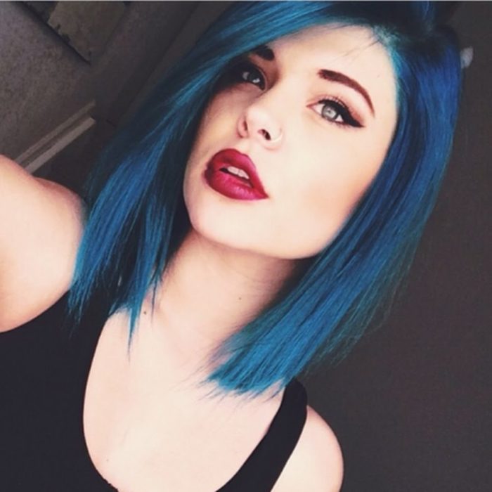 Chica tomándose una selfie para mostrar su cabello corto en azul eléctrico 