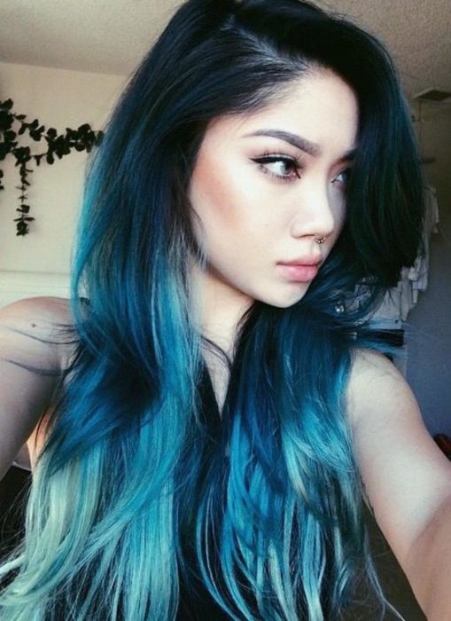 Chica tomándose una selfie de perfil, mostrando su cabello azul eléctrico y aqua