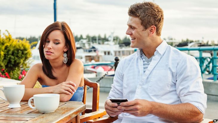 Mujer volteando a ver el celular de su pareja porque intuye que le es infiel