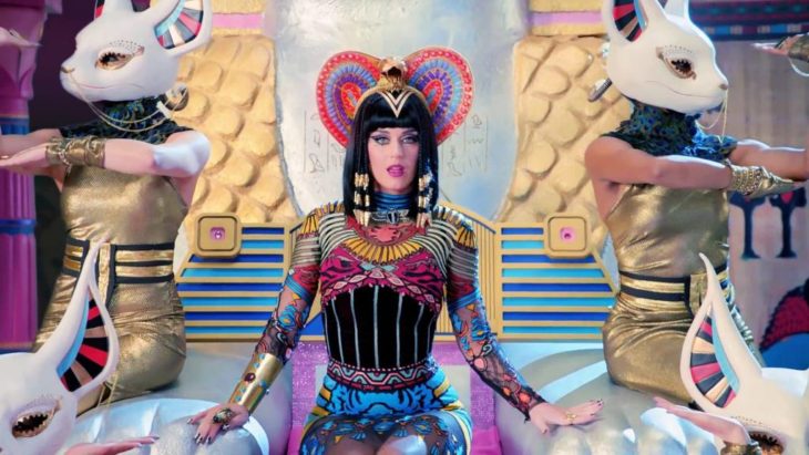 Katy Perry vestida como diosa egipcia con un atuendo de colores y sentada en un trono para la canción Dark Horse 