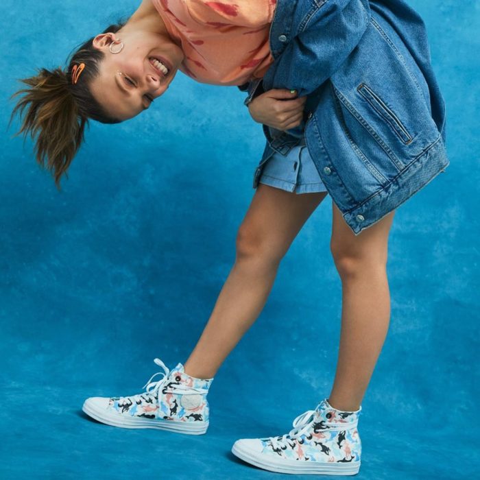 Millie Bobby Brown agachada mostrando sus tenis converse