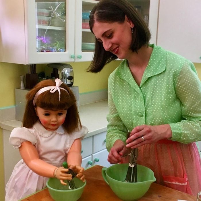 Madeline y Malachi Dressel; mujer cocinando con su muñeca vintage de tamaño real