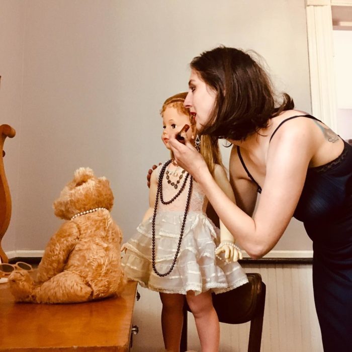 Madeline y Malachi Dressel; mujer maquillándose frente a espejo junto con muñeca vintage de tamaño real