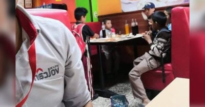 Niños invitan a pequeño vendedor de dulces a comer pizza