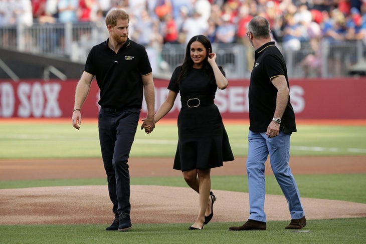 Meghan Markle y el príncipe Harry tomados de la mano en el juego de béisbol