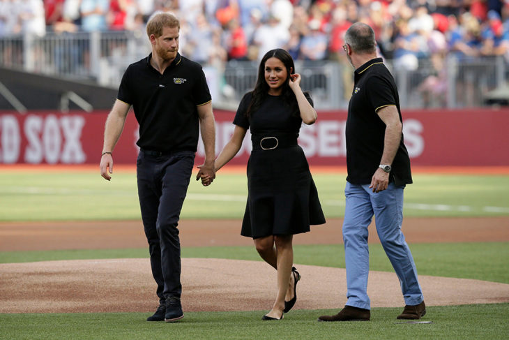 Meghan Markle y el príncipe Harry tomados de la mano en el juego de béisbol