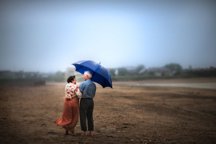 Abuelos caminando del brazo sobre un terreno árido, fotografía de Sujata Setia