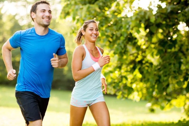 una pareja corriendo en un lugar verde