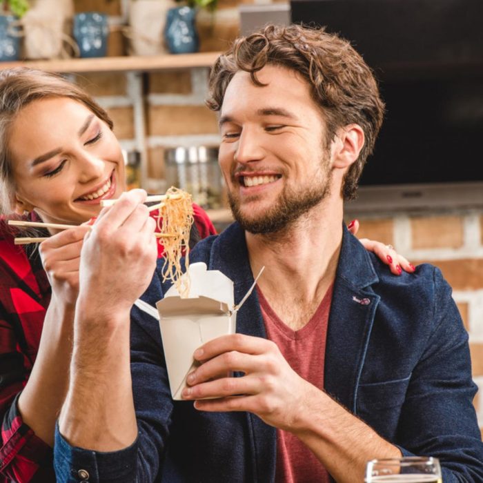 una pareja come pasta de un empaque desechable