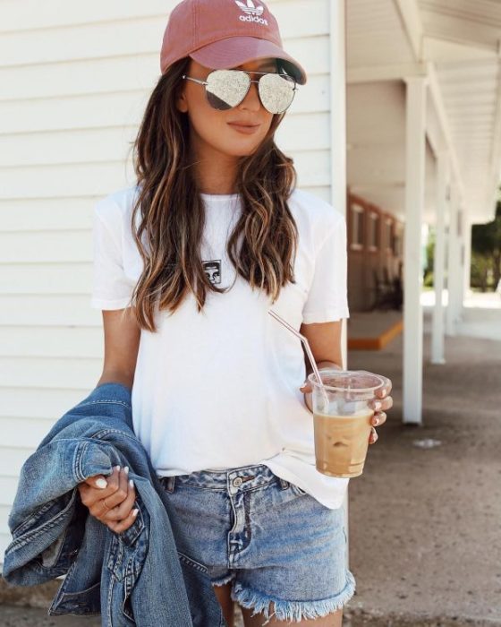 chica usando gorra deportiva y bebiendo agua 