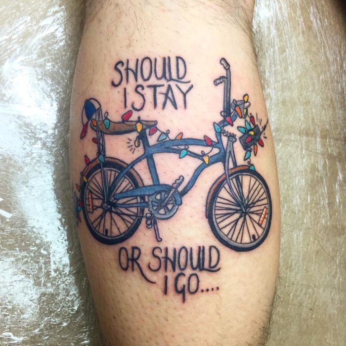 Tatuaje inspirado en Stranger Things con una bicicleta como la de Will y una serie de focos de colores