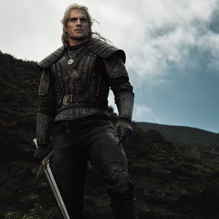 Henry Cavill como el hechicero Geralt de Rivia en serie de Netflix, The Witcher; hombre con cabello largo y blanco con armadura y espada