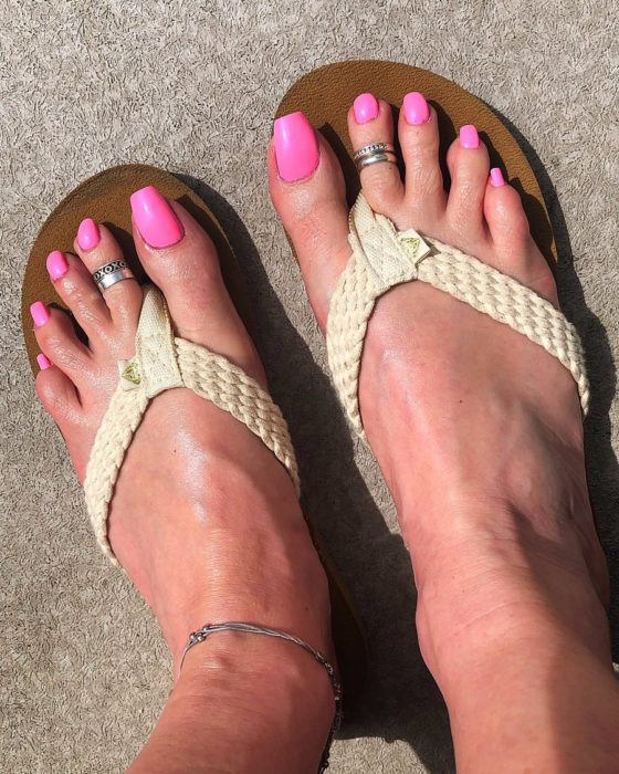 Chica con las uñas de los pies acrílicas en color rosa