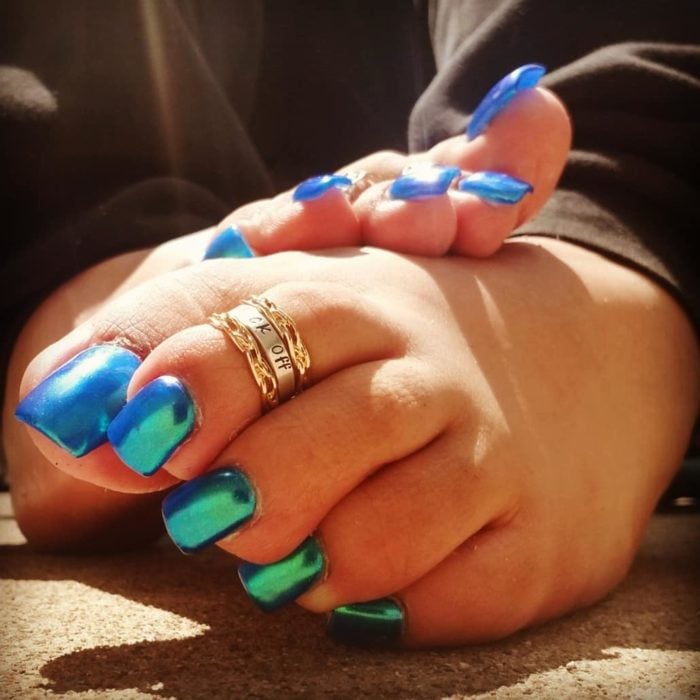 Chica con unas uñas acrilicas de color azul tornasol en los pies 