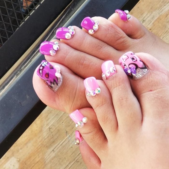 Chica con unas uñas largas acrílicas en color rosa con piedras
