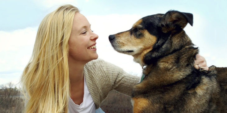 mujer sonriendo con un perro grande