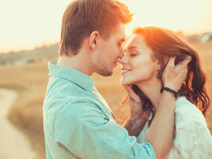 Mujer y hombre muy de cerca bajo el atardecer