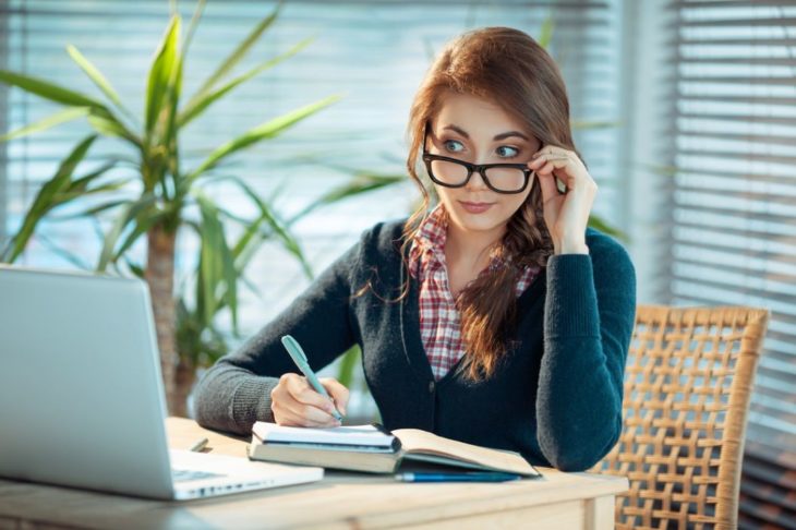 Mujer con lentes mirando la computadora