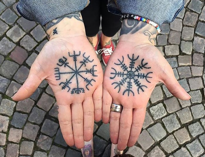 Chica con un tatuaje en las manos con símbolos vikingos 