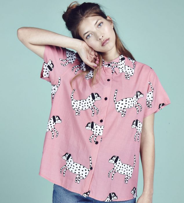 Blusas con estampados bonitos y kawaii; mujer de cabello castaño con camisa rosa con perros dálmata