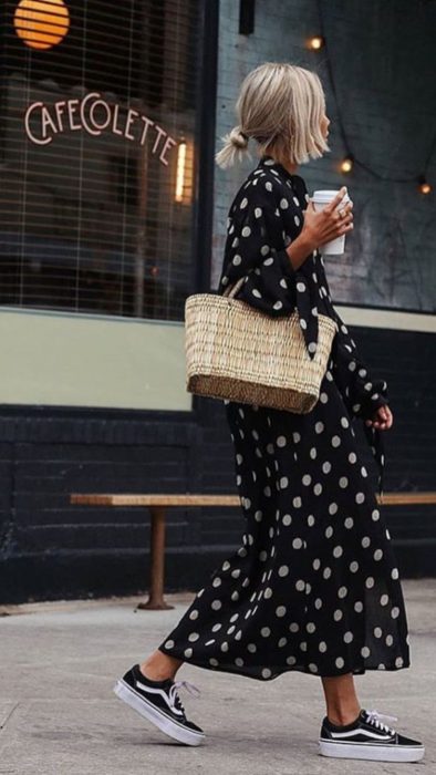 Chica usando un vestido largo con tenis y un bolso de paja 