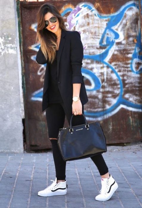 Chica usando un outfit negro con un bolso de mano en color negro 