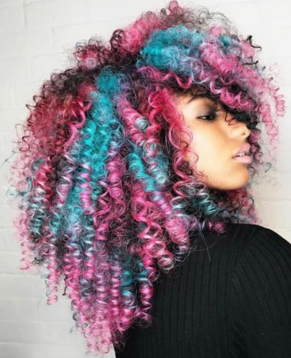 Chica afroamericana con cabello chino, esponjado y teñido de colores rosa y azul