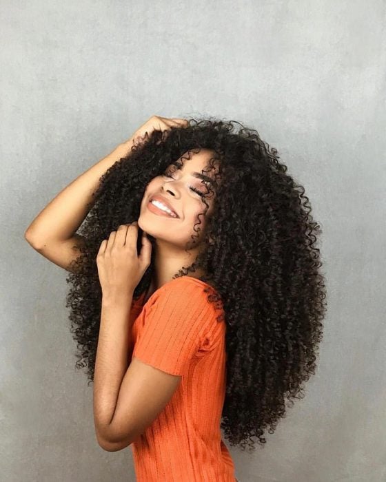 Chica afroamericana con cabello chino, esponjado y largo