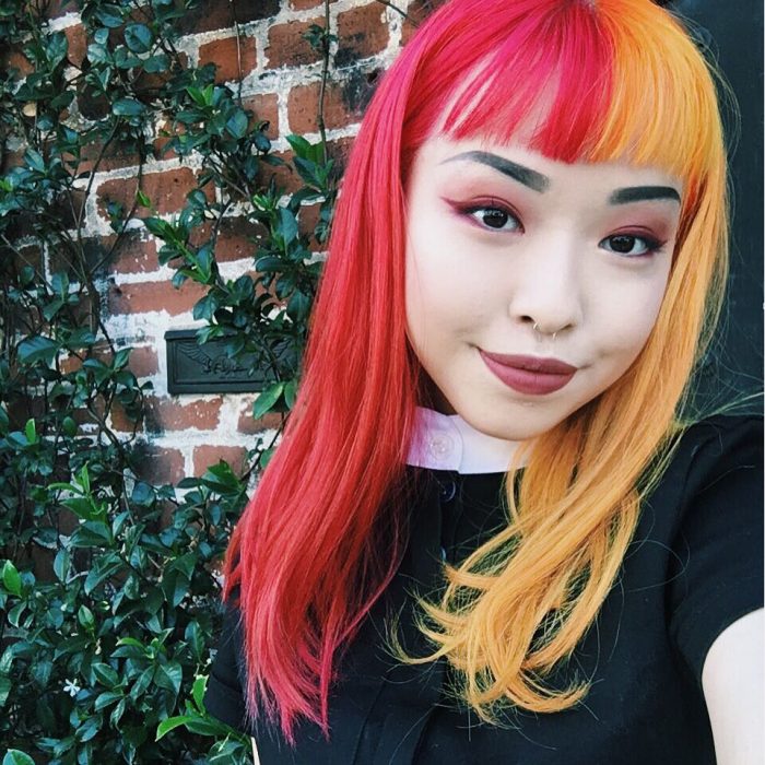 Chica coreana de cabello teñido de dos colores: rosa y anaranjado