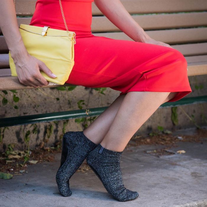 Chica usando un vestido rojo con unos calcetines de color negro diseñados especialmente para caminar por la calle después de bailar 