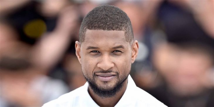 Usher con camisa blanco, mirando al frente en una alfombra roja