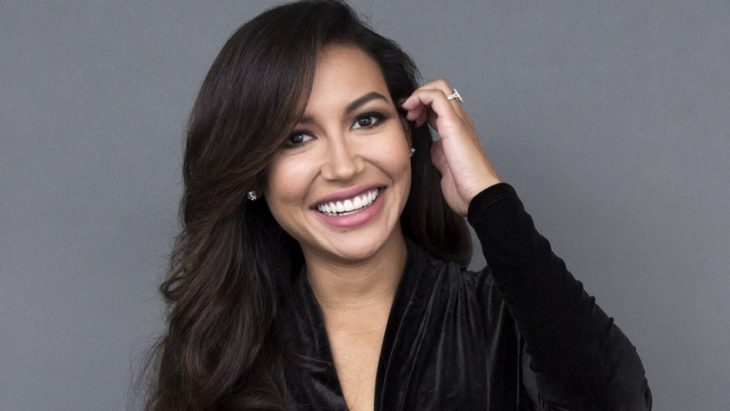 Naya Rivera sonriendo, llevando su cabello por detrás de los oidos