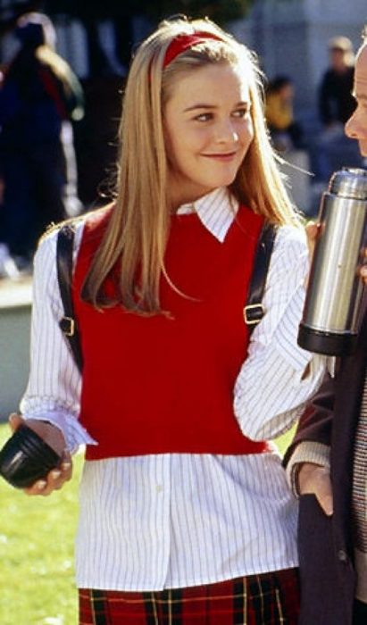 Cher de Clueless usando una blusa blanca y un chaleco de color rojo 