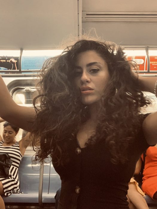 Chica en un vagón del metro de Nueva York tomándose una selfie 