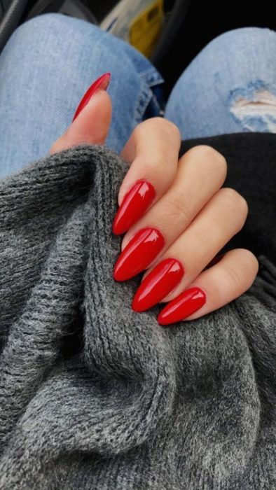 Manos de una mujer con las uñas pintadas de color rojo 
