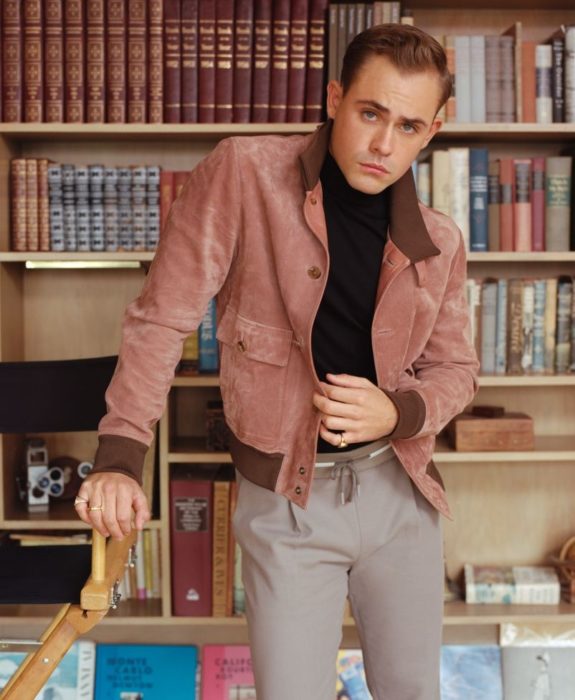 Fotos de Dacre Montgomery con abrigo rosa en una biblioteca