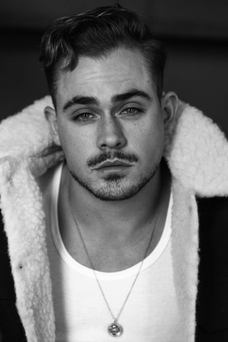 Fotos de Dacre Montgomery con abrigo y bigote, fotografía en blanco y negro